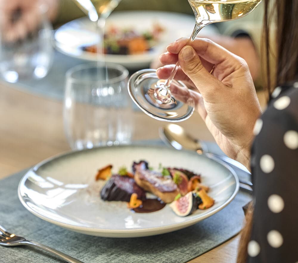Table privée élégamment dressée avec un plat gastronomique, prête à accueillir une expérience de dégustation dans un cadre intimiste.